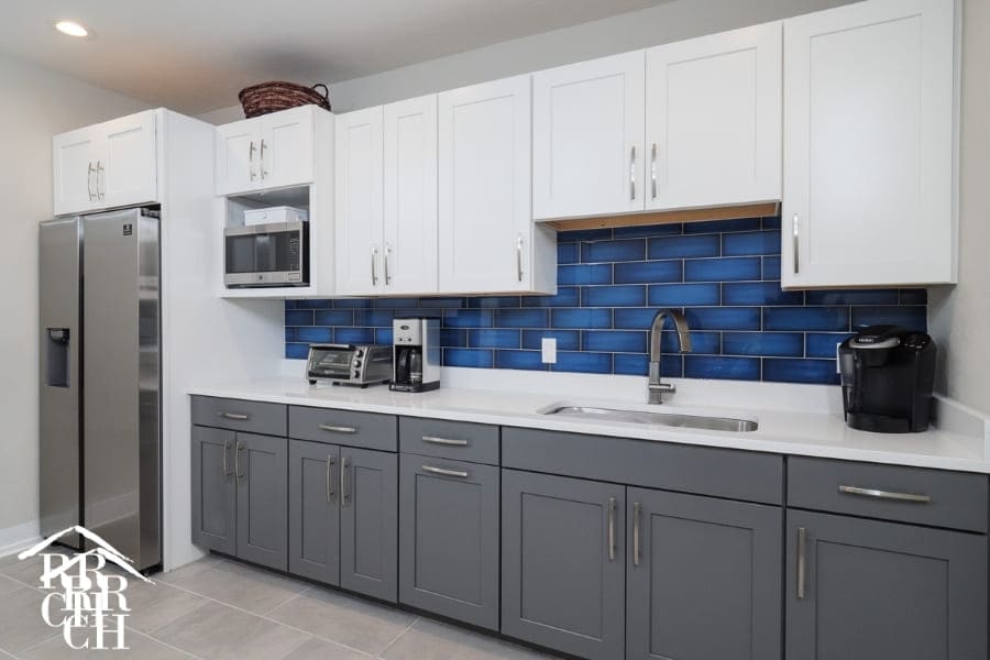 Commercial Office Renovation Staff Kitchen with Blue Backsplash and Beautiful Grey Cabinet with White Cabinet Accepts | Robinson Renovation and Custom Homes